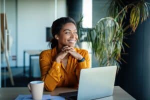 Woman sitting at laptop with a smile on her face