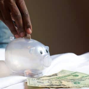 Person depositing coins into a piggy bank